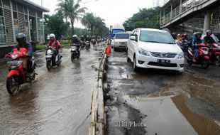 FOTO BANJIR JAKARTA : Melintasi Jalan Berlubang 