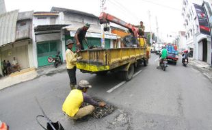 JALAN  BERLUBANG : Menambal Lubang 