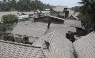 FOTO GUNUNG KELUD MELETUS : Membersihkan Atas Rumah Dari Material Vulkanik