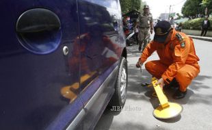 FOTO RAZIA PARKIR LIAR : Memasang Gembok Roda Mobil