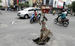 FOTO JALAN BERLUBANG : Dipasang bambu dan bendera