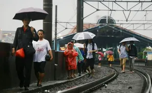 FOTO BANJIR JAKARTA : KRL Terganggu, Penumpang Jalan Kaki