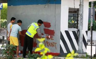 FOTO VANDALISME JOGJA : Remaja Hapus Grafitti di Pos Polisi