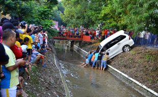 FOTO MOBIL NYEMPLUN SELOKAN : Warga Angkat Mobil Nyemplung ke Selokan