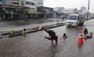 Foto Anak-Anak Renang di Genangan Air Jl. Slamet Riyadi Solo